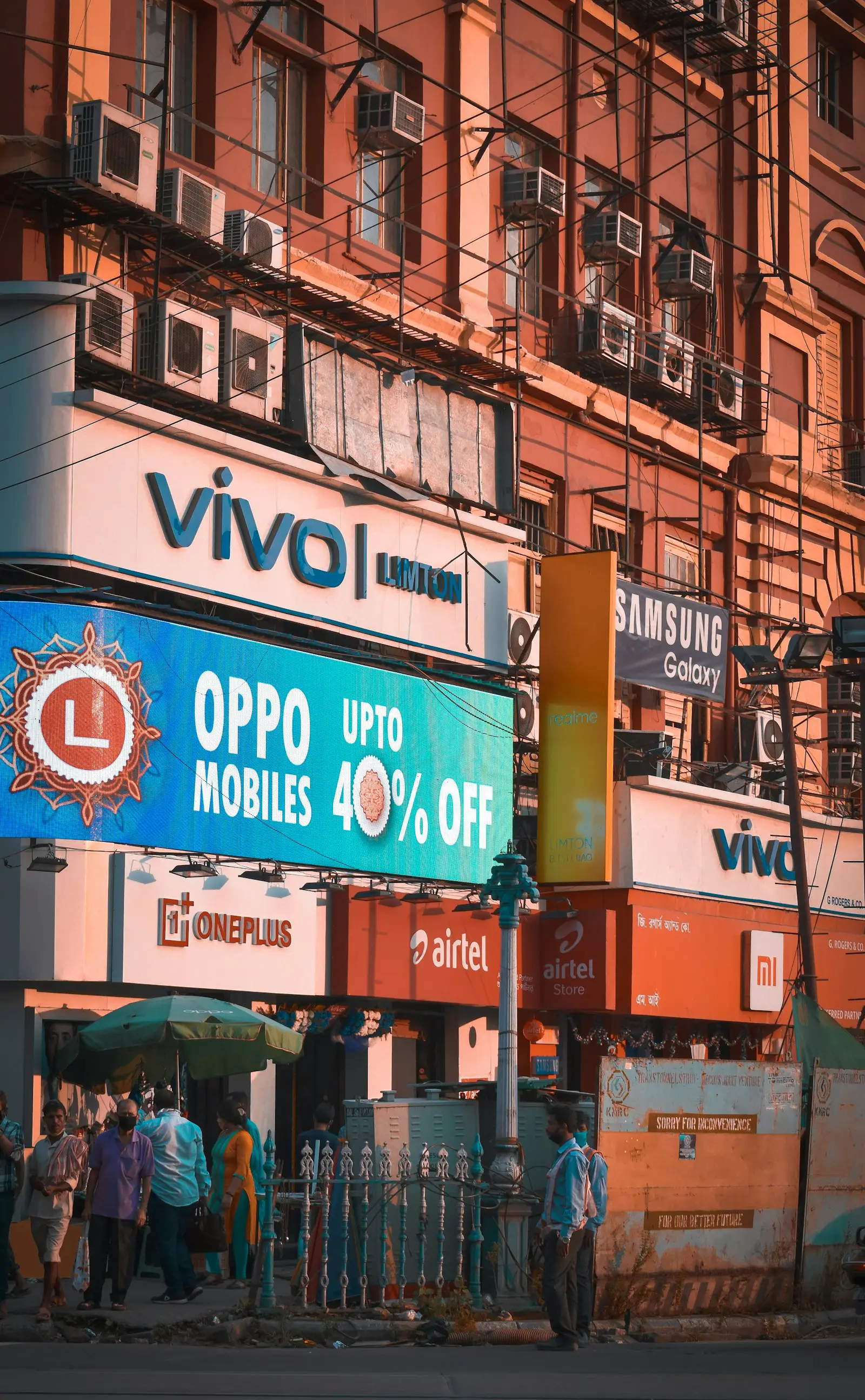 Mobile brand signage and an offer banner above Indian shopfronts